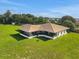 Aerial view of single-story home featuring a brown roof, screened-in porch, and a large grassy yard at 553 Thornburg Rd, Babson Park, FL 33827