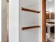 Hallway displaying shelving leads into a bathroom with a pedestal sink and classic fixtures, combining style and functionality at 553 Thornburg Rd, Babson Park, FL 33827