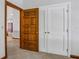 Neutral room featuring carpeted floors, white walls, and trim, including an open carved wooden door and closet at 553 Thornburg Rd, Babson Park, FL 33827