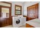 Laundry room with front loading washer and dryer, white counters, wooden framed doors, window, and trim at 553 Thornburg Rd, Babson Park, FL 33827