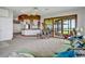 A naturally-lit living room features plush furniture, an open floor plan, and large windows offering serene outdoor views at 553 Thornburg Rd, Babson Park, FL 33827