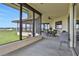 Enclosed patio, furnished with outdoor furniture with views of the green lawn and the canal at 553 Thornburg Rd, Babson Park, FL 33827