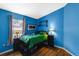 Bedroom with blue walls and hardwood floors at 59 Saint Kitts Cir, Winter Haven, FL 33884