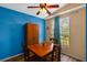 Dining area with blue accent wall, wooden table, and natural light from the window at 59 Saint Kitts Cir, Winter Haven, FL 33884