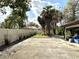 Backyard with a concrete patio and privacy fence, with mature trees at 605 Wanamaker Ave, Fort Meade, FL 33841