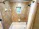 Bathroom featuring a tiled shower, a grab bar, and a bright window at 605 Wanamaker Ave, Fort Meade, FL 33841