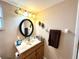 Bathroom vanity featuring wood cabinets, mirror, updated light fixture, and sink with marble-look countertop at 605 Wanamaker Ave, Fort Meade, FL 33841