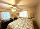 Comfortable bedroom featuring a floral comforter, ceiling fan, and windows for natural light at 605 Wanamaker Ave, Fort Meade, FL 33841