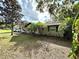 A charming home featuring mature landscaping with palms and trees in a large open yard at 605 Wanamaker Ave, Fort Meade, FL 33841