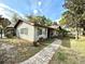 Exterior of the home showcasing the walkway, lush landscaping, and architectural details at 605 Wanamaker Ave, Fort Meade, FL 33841
