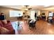 Inviting living room featuring hardwood floors, a ceiling fan, and a well-lit and open layout at 605 Wanamaker Ave, Fort Meade, FL 33841