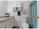 Bright bathroom featuring granite countertop, cabinet, toilet, and decorative blue shower curtain at 608 William Ave, Winter Haven, FL 33880