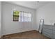 Bright bedroom with window, white curtains, and gray dresser at 608 William Ave, Winter Haven, FL 33880