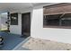 View of front entrance with a dark door, window, and landscaping with small rocks at 608 William Ave, Winter Haven, FL 33880