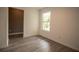 Cozy bedroom with a window offering a view of the outdoors and wood-look laminate flooring at 612 Muskrat Dr, Kissimmee, FL 34759