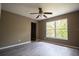 Bedroom with light gray wood floors, a window, and a ceiling fan at 612 Muskrat Dr, Kissimmee, FL 34759