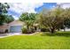 Charming single-story home features a well-manicured lawn, mature trees, and an attached two-car garage at 612 Muskrat Dr, Kissimmee, FL 34759