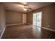 Bright living room featuring wood-look flooring and a sliding glass door to a patio at 612 Muskrat Dr, Kissimmee, FL 34759