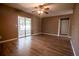 Spacious living room featuring sleek wood floors, ceiling fan, and sliding doors to screened porch at 612 Muskrat Dr, Kissimmee, FL 34759
