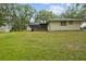 Expansive backyard with verdant lawn and mature trees, complemented by a shed for extra storage at 6320 Newman E Cir, Lakeland, FL 33811
