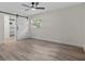 Bedroom with light floors, white walls, fan and barn door to the bathroom at 6320 Newman E Cir, Lakeland, FL 33811