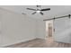Bright bedroom features barn door to bathroom, light floors and fan at 6320 Newman E Cir, Lakeland, FL 33811