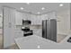Modern kitchen with white cabinets, stainless steel appliances, and quartz countertops at 6320 Newman E Cir, Lakeland, FL 33811
