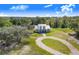 Sprawling property features a charming home with a metal roof, circular driveway, and lush surroundings at 6344 Old Lake Wilson Rd, Davenport, FL 33896
