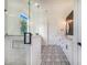 Bright bathroom featuring patterned tile floors, black hardware, and a glass shower enclosure at 6344 Old Lake Wilson Rd, Davenport, FL 33896