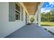 Spacious covered patio featuring sleek flooring and a comfortable swing for relaxing outdoors at 6344 Old Lake Wilson Rd, Davenport, FL 33896