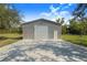 Exterior view of a metal building with a large garage door and concrete driveway at 6344 Old Lake Wilson Rd, Davenport, FL 33896