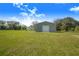 View of the backyard including a new metal garage and lush green grass at 6344 Old Lake Wilson Rd, Davenport, FL 33896