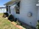 The home's light-colored exterior with a brick-lined landscape is complimented by shuttered windows and green lawn at 6398 Lolly Bay Ne Loop, Winter Haven, FL 33881