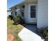 The home's front entrance features a pathway, mature landscaping, and a glass storm door at 6398 Lolly Bay Ne Loop, Winter Haven, FL 33881