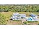 An elevated view of a blue home with a pool, carport and verdant landscaping at 6925 Alturas Babson Park Cutoff, Bartow, FL 33830