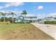 Stunning two-story home with a metal roof, light blue siding and a well-maintained lawn with palm trees at 6925 Alturas Babson Park Cutoff, Bartow, FL 33830