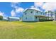 Spacious lot featuring a two-story light blue home with a metal roof, covered porch and a detached garage at 6925 Alturas Babson Park Cutoff, Bartow, FL 33830