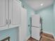 Modern laundry room equipped with stacked washer and dryer units and cabinet storage at 6925 Alturas Babson Park Cutoff, Bartow, FL 33830