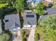 Aerial view of a home with a long driveway, landscaping, and solar panels at 711 Lake Dexter Cir, Winter Haven, FL 33884