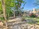 Backyard featuring multiple trees and partial fence with a house and chimney in background at 711 Lake Dexter Cir, Winter Haven, FL 33884