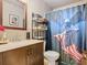 Cozy bathroom featuring a vanity with a modern faucet, toilet, and shower with themed curtain at 711 Lake Dexter Cir, Winter Haven, FL 33884