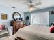 Cozy bedroom featuring a light blue wall, wooden bed frame, dresser, and ample natural light at 711 Lake Dexter Cir, Winter Haven, FL 33884