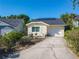 Home boasts solar panels, driveway, garage, and flowering shrubs, enhancing curb appeal and energy efficiency at 711 Lake Dexter Cir, Winter Haven, FL 33884