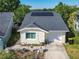 Charming home featuring a gray roof with solar panels, well-kept lawn, and attached one car garage at 711 Lake Dexter Cir, Winter Haven, FL 33884