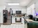 Modern kitchen with stainless steel appliances, white cabinets and black countertops providing a clean, functional space at 711 Lake Dexter Cir, Winter Haven, FL 33884