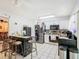 Modern kitchen featuring stainless steel appliances, breakfast bar, and white tile flooring at 711 Lake Dexter Cir, Winter Haven, FL 33884