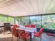Enclosed patio featuring outdoor dining set, grill, and views of the surrounding greenery at 711 Lake Dexter Cir, Winter Haven, FL 33884
