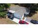 Aerial view of a single-story home with white siding and a concrete driveway with multiple cars parked at 730 Druid St, Lakeland, FL 33805