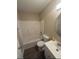 Standard bathroom with shower over tub, modern vanity, round mirror and wood-look flooring at 730 Druid St, Lakeland, FL 33805