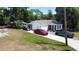 Charming single-story home with white siding, dark shutters and trim, and a concrete driveway with multiple cars parked at 730 Druid St, Lakeland, FL 33805